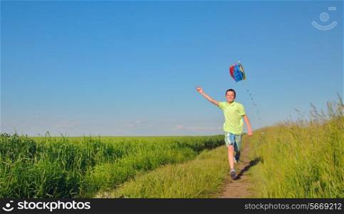 boy running with kite in the field