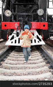 Boy runs before locomotive