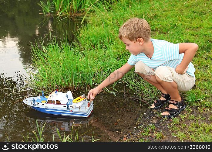 boy sends toy ship in floating