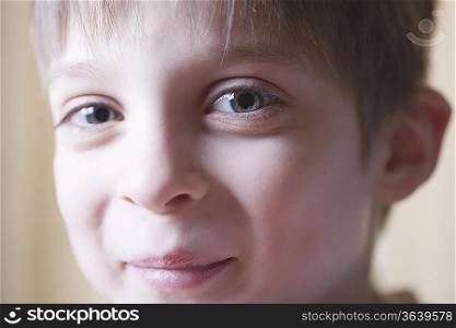 Boy sits smiling at camera