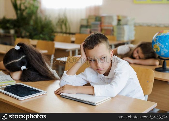 boy sitting classroom looking away
