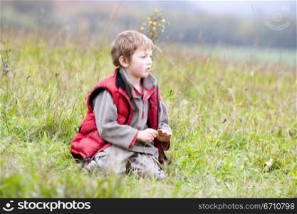 Boy sitting in the grass