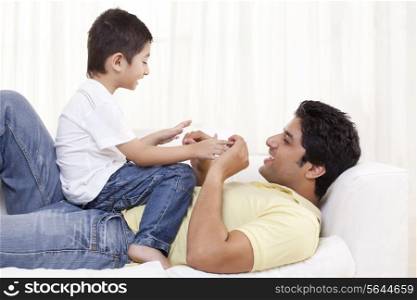 Boy sitting on father at home