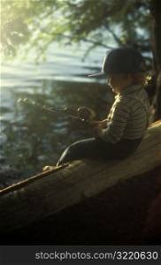 Boy Sitting On Log And Fishing