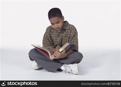 Boy sitting on the floor reading a book