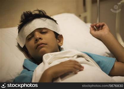 Boy sleeping with a damp cloth on his forehead