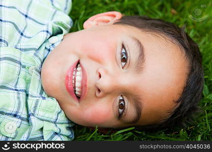 Boy smiling on grass, portrait