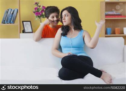 Boy standing behind his sister playing with her hair
