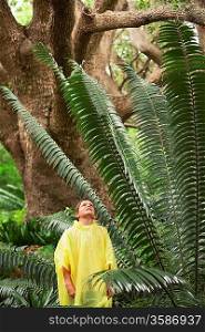 Boy Standing by Large Fern