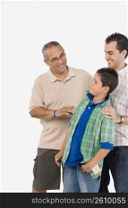 Boy standing with his father and grandfather