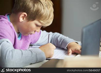 Boy Studying In Bedroom Using Laptop