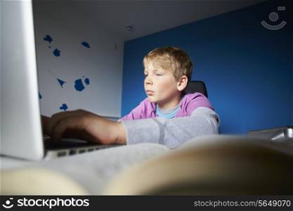 Boy Studying In Bedroom Using Laptop