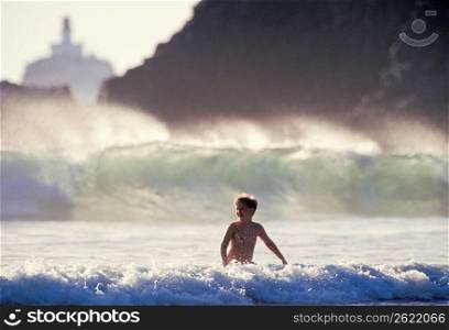 Boy swimming in waves