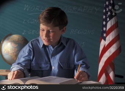 Boy Taking Notes In Geography Classroom