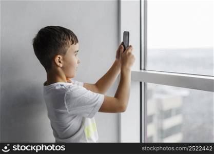 boy taking pictures with his mobile phone