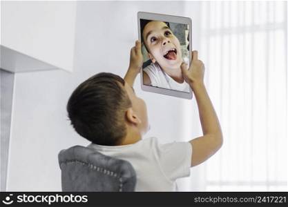 boy taking self portrait digital tablet