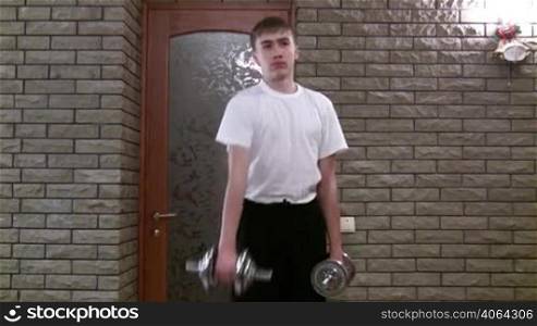 boy-teenager does exercise with dumbbells.