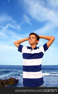 boy teenager hands in head relaxed in blue ocean sea beach summer vacation