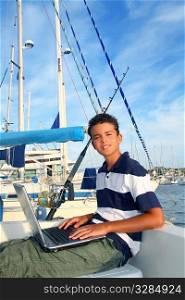 boy teenager seat on boat marina laptop computer summer vacation