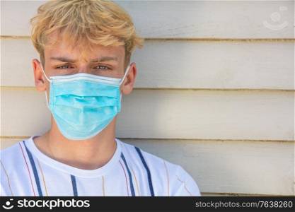 Boy teenager teen male young man wearing a face mask outside during the Coronavirus COVID-19 virus pandemic