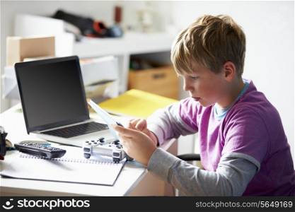 Boy Using Digital Tablet In Bedroom