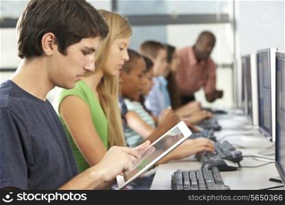Boy Using Digital Tablet In Computer Class