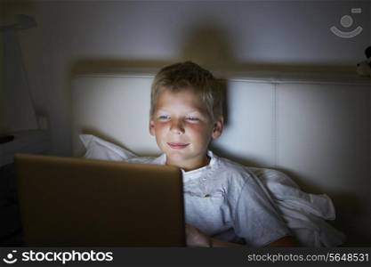 Boy Using Laptop In Bed At Night