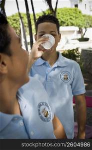 Boy wearing school uniform drinking