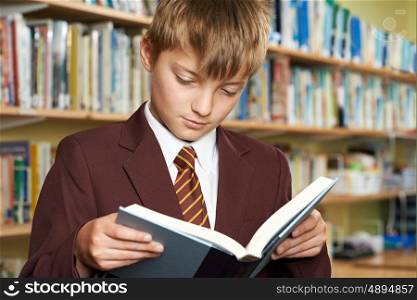 Boy Wearing School Uniform Reading Book In Library