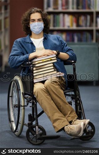 boy wheelchair holding bunch books