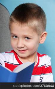 boy with a book, child on a blue background holding an open book