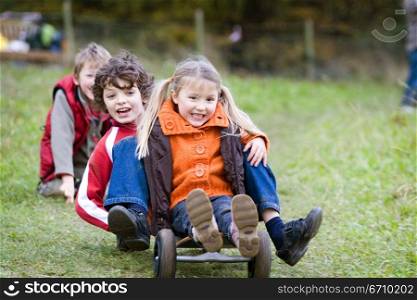 Boy with a girl riding a mountain board in a park