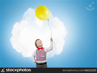 Boy with balloon. Little boy wearing red bowtie holding colorful balloon