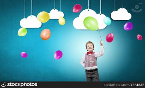 Boy with balloon. Little boy wearing red bowtie holding colorful balloon