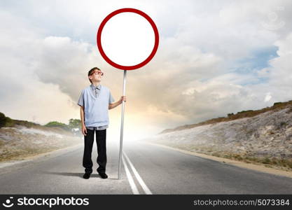 Boy with banner. Boy of school age in glasses holding blank road sign