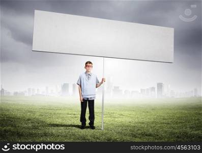 Boy with banner. Boy of school age in glasses holding blank white banner