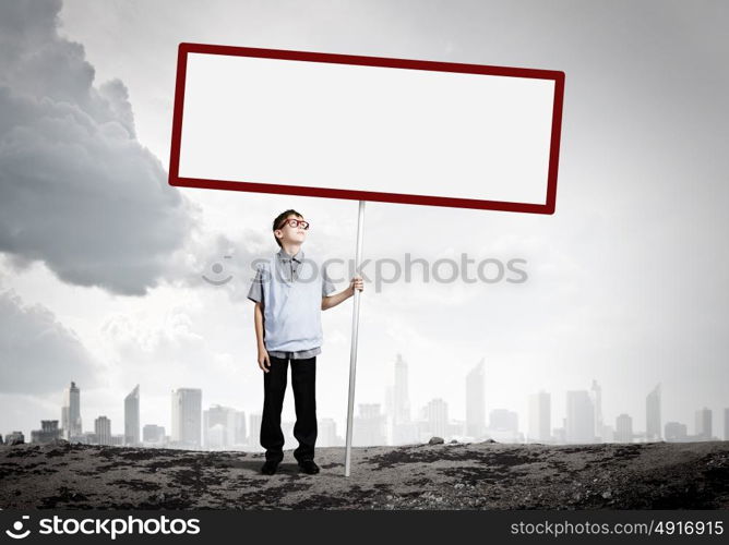 Boy with banner. Boy of school age in glasses holding blank white banner