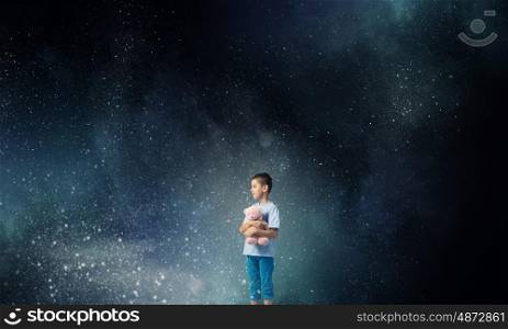 Boy with bear toy. Cute little boy with toy bear in night darkness