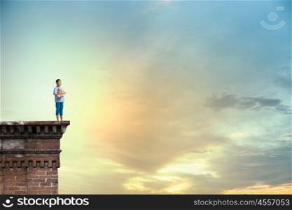 Boy with bear toy. Cute little boy with toy bear on building top