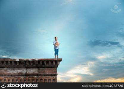 Boy with bear toy. Cute little boy with toy bear on building top