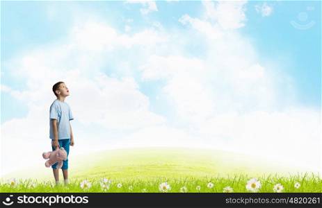 Boy with bear toy. Cute little boy with toy bear on cloud background