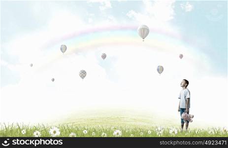 Boy with bear toy. Cute little boy with toy bear on cloud background