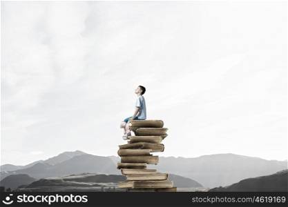 Boy with bear toy. Cute little boy with toy bear sitting on pile of books