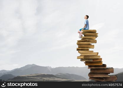 Boy with bear toy. Cute little boy with toy bear sitting on pile of books