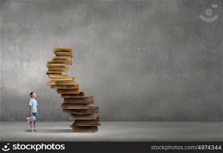 Boy with bear toy. Cute little boy with toy bear sitting on pile of books