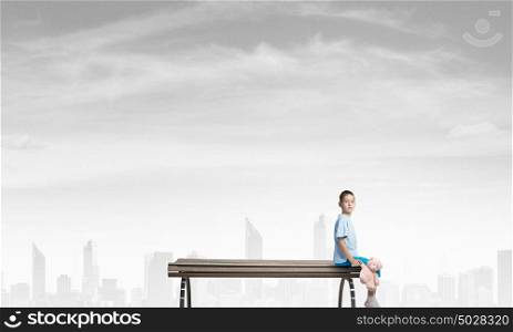 Boy with bear toy. Cute little boy with toy bear sitting on wooden bench