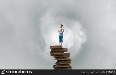 Boy with bear toy. Cute little boy with toy bear standing on pile of books