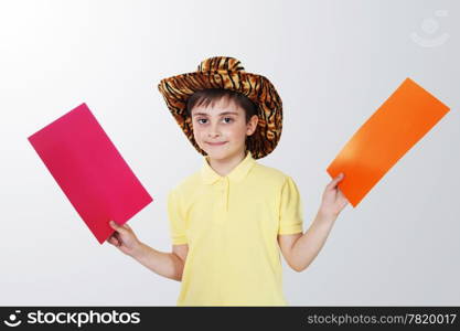 boy with colored paper in his hands on the grey background