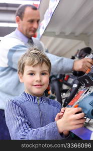 boy with elderly man in shop of electrotools