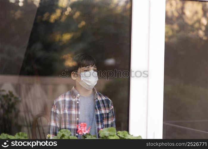 boy with face mask looking outdoors